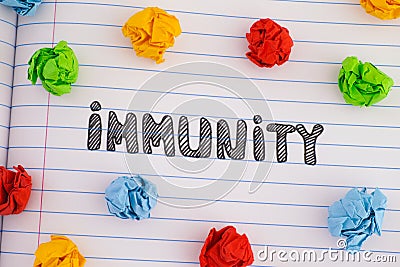 The word Immunity on notebook sheet with some colorful crumpled paper balls around it Stock Photo