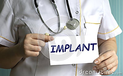 concept word IMPLANT in the hands of a doctor Stock Photo