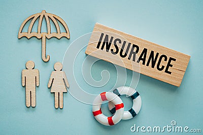 the word Insurance on a wooden block, Wooden shapes of people under the insurers protective umbrella, lifebuoys, Property and Stock Photo