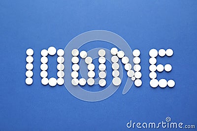 Word Iodine made of pills on blue background, flat lay Stock Photo