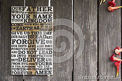 Word of the Lord`s Prayer on the shabby wooden plank with red Stock Photo