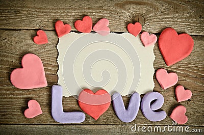 Word Love composition on the wooden board surface and many hearts Stock Photo