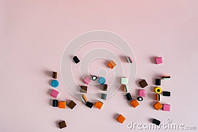 Word Love made of Colorful liquorice allsorts candy on pink background. Copyspace Stock Photo