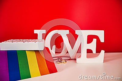 Word love white with yellow gold rings and gay pride flag Stock Photo