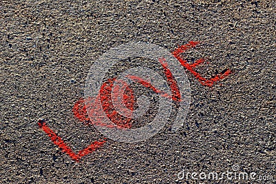 Word LOVE written on the asphalt, ground. Red color of chalk. Stock Photo