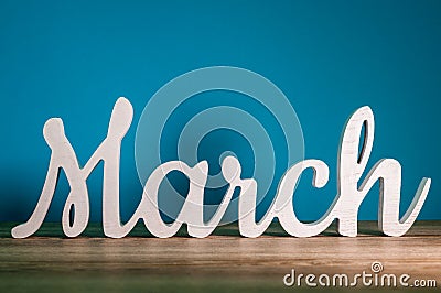 The word MARCH - wooden text at dark blue background. Spring concept Stock Photo