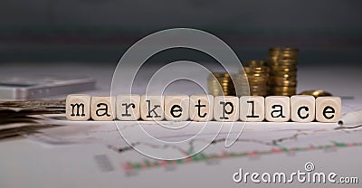 Word MARKETPLACE composed of wooden letter. Stacks of coins in the background Stock Photo