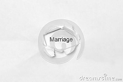 Word Marriage on white isolated background through the wound hole in the paper. Stock Photo