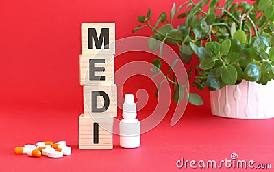 The word MEDI is made of wooden cubes on a red background. Medical concept Stock Photo