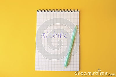 Word Mistake written with erasable pen in notepad on yellow background, top view Stock Photo