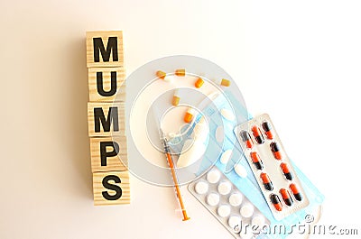 The word MUMPS is made of wooden cubes on a white background. Medical concept Stock Photo