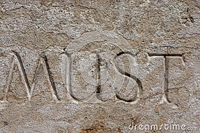 The word Must written in stone Stock Photo