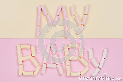 The word my baby is written by a pastel marshmallow on a white background. Stock Photo