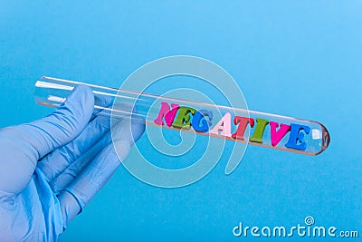 Word negative in test-tube holding a gloved hand Stock Photo