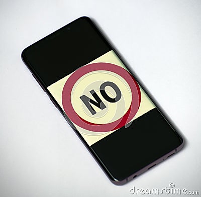 The word No entered in red circle on the smartphone screen Stock Photo
