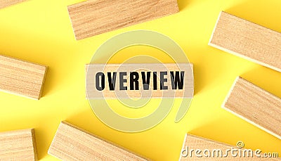 The word OVERVIEW is written on a wooden blocks on a yellow background. Stock Photo