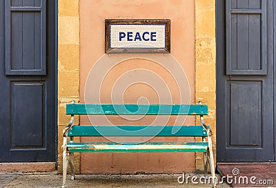 Word peace framed above an old wooden bench on a column. Close up view. Stock Photo