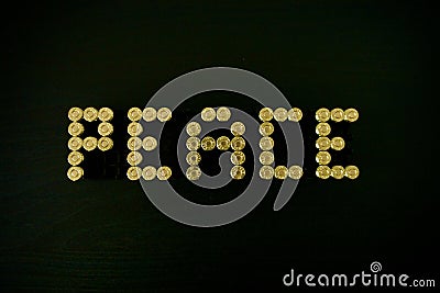 Word Peace made of 9 mm ammo on black wooden desk, golden bullets Stock Photo