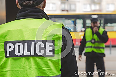Close-up of word police written on reflective vests of police officers Stock Photo