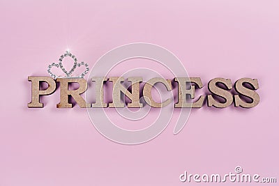 Word Princess abstract wooden letters. Pink background with sparkling crown. Stock Photo