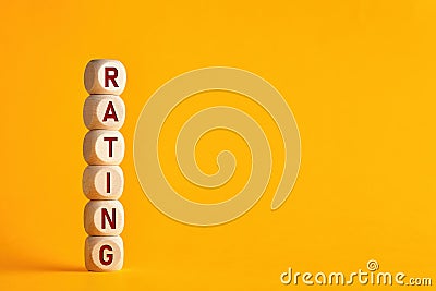 The word rating on wooden cubes against yellow background. Improvement in service rating and customer evaluation concept. Stock Photo