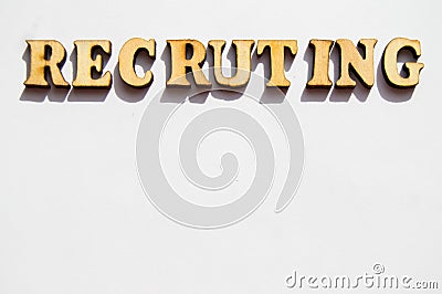 The word recruiting is written in wooden letters on a white background, the concept of hiring employees, recruitment in business Stock Photo
