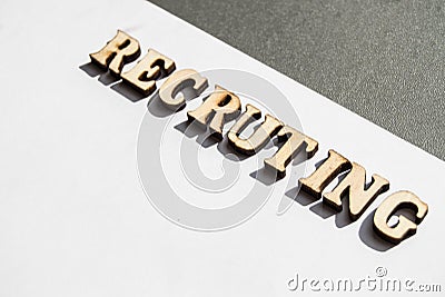 The word recruiting is written in wooden letters on a white background, the concept of hiring employees, recruitment in business Stock Photo