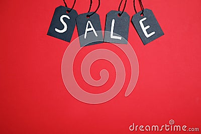 Word SALE made with black tags on red background, flat lay. Space for text Stock Photo
