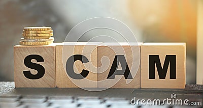 Word SCAM. Wooden small cubes with letters isolated on computer keyboards with copy space available. Concept image Stock Photo