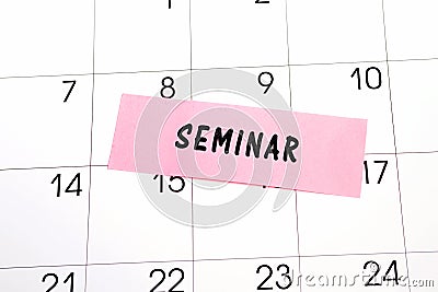 The word Seminar written on a pink sticky note posted on a calendar or planner page. Closeup of a personal agenda Stock Photo