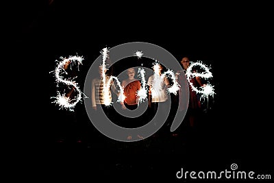 The word shine written with sparklers against a black background Stock Photo