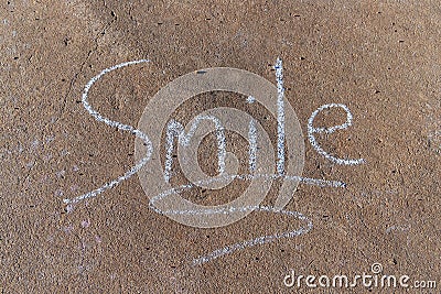 The word Smile written with sidewalk chalk on gray concrete Stock Photo