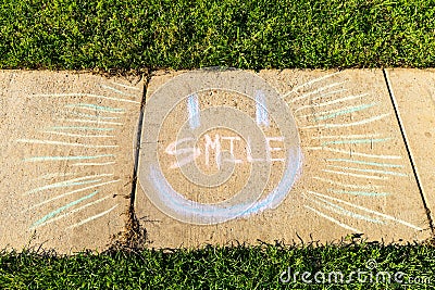 The word `Smile` written with sidewalk chalk Stock Photo