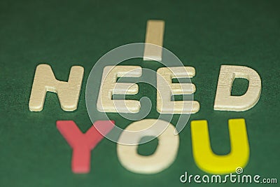 The word spelling to `I need you` on green background Stock Photo