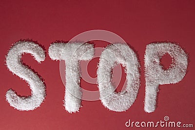 The word STOP written by sugar grains on red background Stock Photo