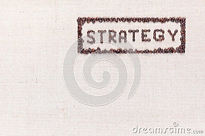 The word Strategy inside a rectangle all made using coffee beans shot from above, aligned to the top right Stock Photo