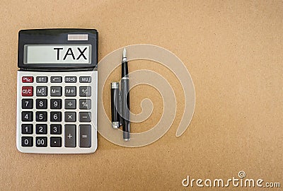 The word `tax` on the scoreboard calculator. Calculator with a black pen on a wooden table. view from above. Copy space. Tax conce Stock Photo