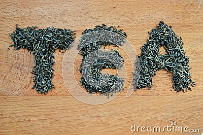 Word tea made from loose leaf tea on wooden background Stock Photo