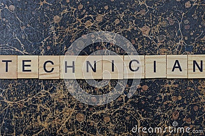 Word technician from wooden letters in black font on a brown shabby wall Stock Photo