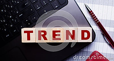 The word TREND is written on wooden cubes on the keyboard. Business concept Stock Photo