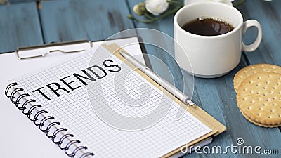 Word TRENDS in Notepad. Female hand writing Stock Photo