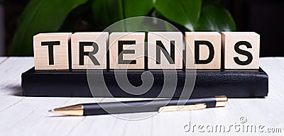 The word TRENDS is written on the wooden cubes of the diary near the handle Stock Photo