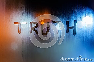 The word truth written on night wet window glass close-up with bokeh background Stock Photo