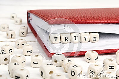 Word Truth written in wooden blocks in red notebook on white wo Stock Photo