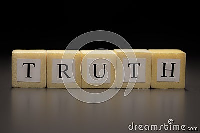 The word TRUTH written on wooden cubes, isolated on a black background Stock Photo