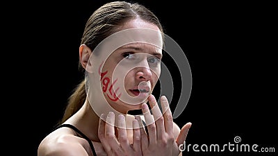 Word ugly written on lady cheek, woman feeling scared and unprotected insecurity Stock Photo