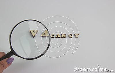 The word vacancy of wooden letters and a magnifying glass Stock Photo