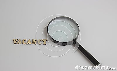 The word vacancy of wooden letters and a magnifying glass Stock Photo