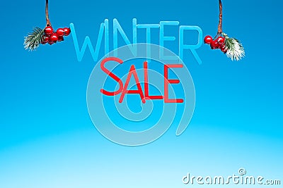 The word WINTER SALE capital letters and Christmas decoration on blue background Stock Photo