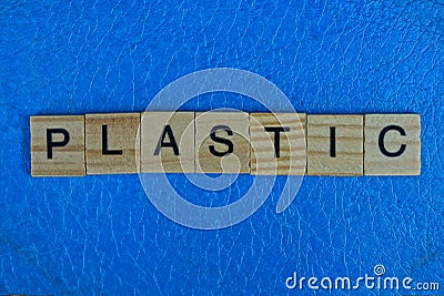 Word from wooden letters lies on a piece of blue plastic Stock Photo